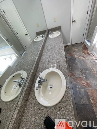 A bathroom with two sinks and a mirror.