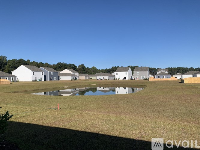 A row of houses with a pond in the foreground.