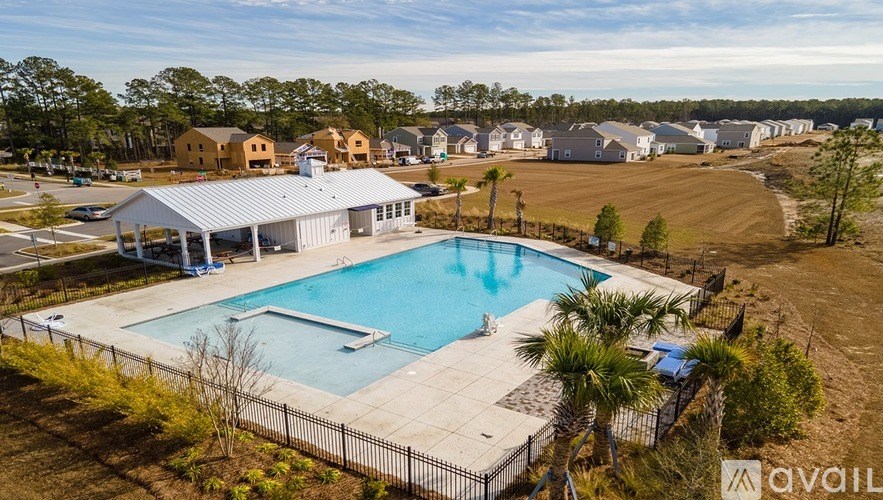 A swimming pool surrounded by a fence and a building in the background.