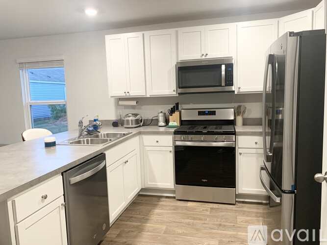 A kitchen with white cabinets and stainless steel appliances.