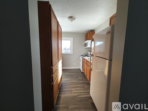 A kitchen with wooden cabinets and a white refrigerator.