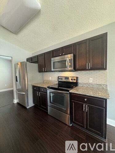 A kitchen with dark wood cabinets and stainless steel appliances.