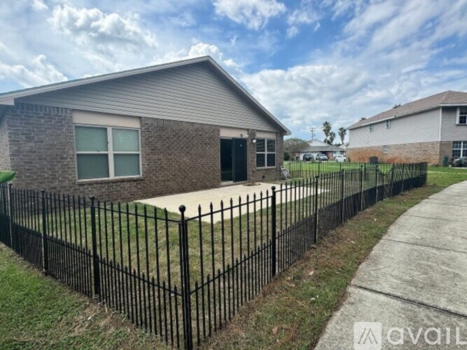 A house with a black fence and a grey roof.