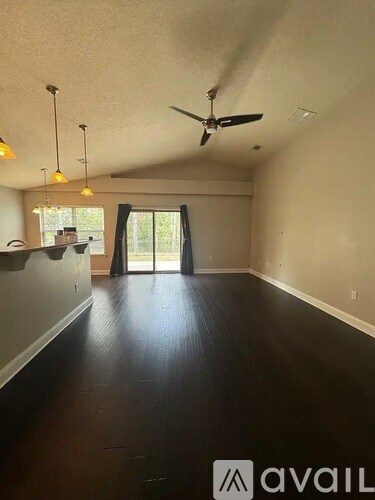 A room with a ceiling fan and hanging lights.