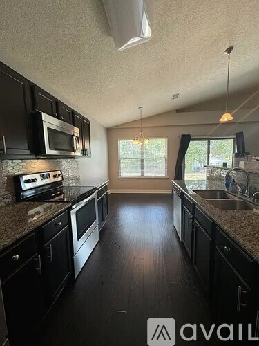 A kitchen with black cabinets and granite countertops.