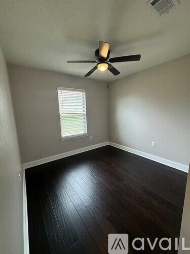 A room with a ceiling fan and a window with blinds.