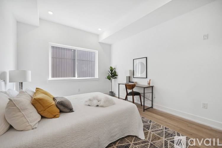 A bedroom with a bed, desk, and chair.