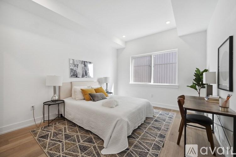 A bedroom with a bed, desk, and chair.