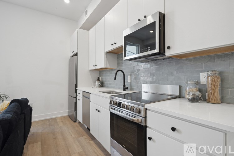 A modern kitchen with white cabinets and stainless steel appliances.