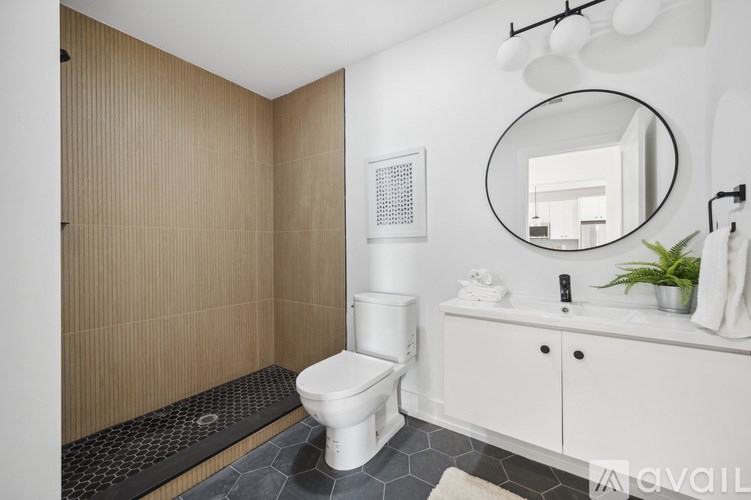 A bathroom with a toilet, sink, and mirror.