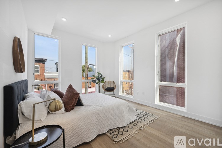 A bedroom with a large bed and a window overlooking a cityscape.
