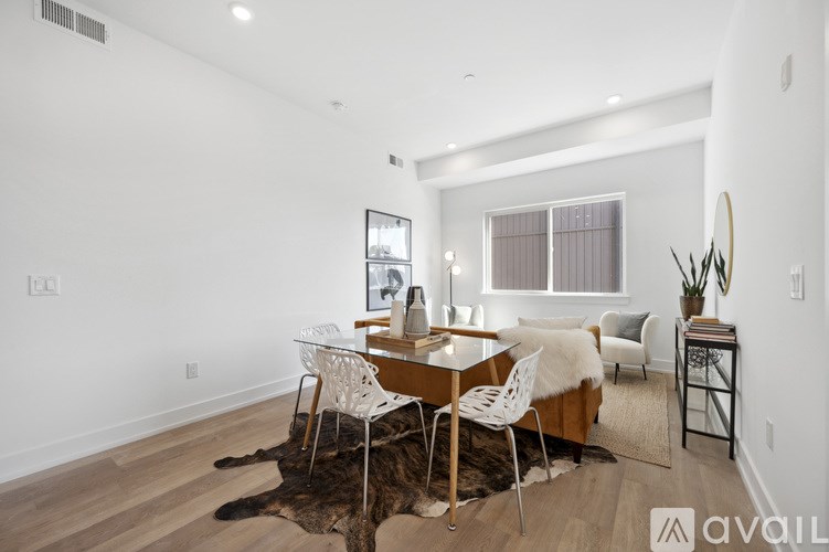 A room with a cowhide rug and a wooden table with chairs.