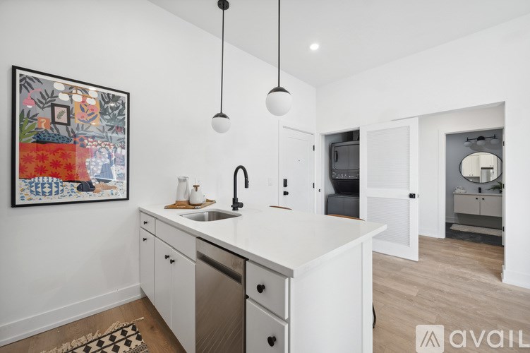 A kitchen with white cabinets and a framed picture on the wall.