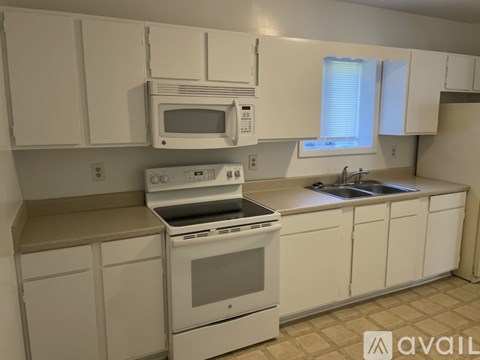 A kitchen with white appliances and cabinets.