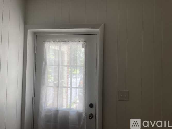 A white door with a glass window and a white curtain.