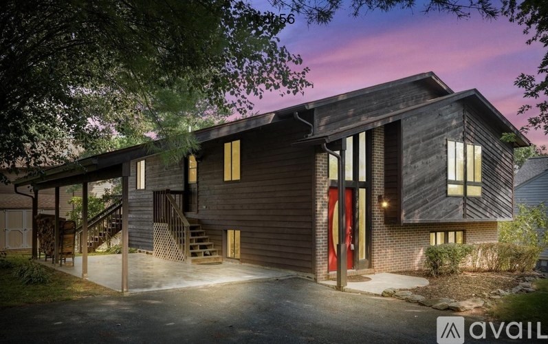 A modern house with a red door is available for purchase.
