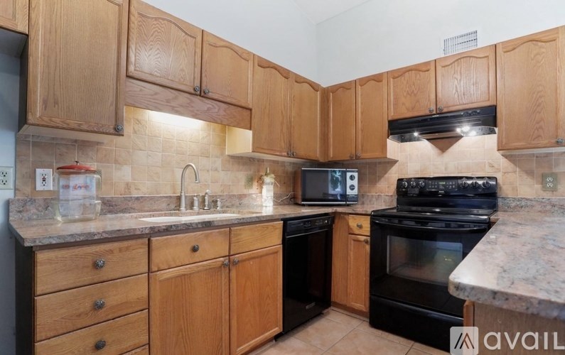 A kitchen with wooden cabinets and a black stove top oven.