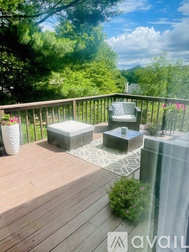 A wooden deck with a white chair and a table.