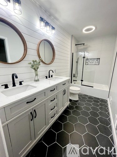 A bathroom with a sink, toilet, and mirror.