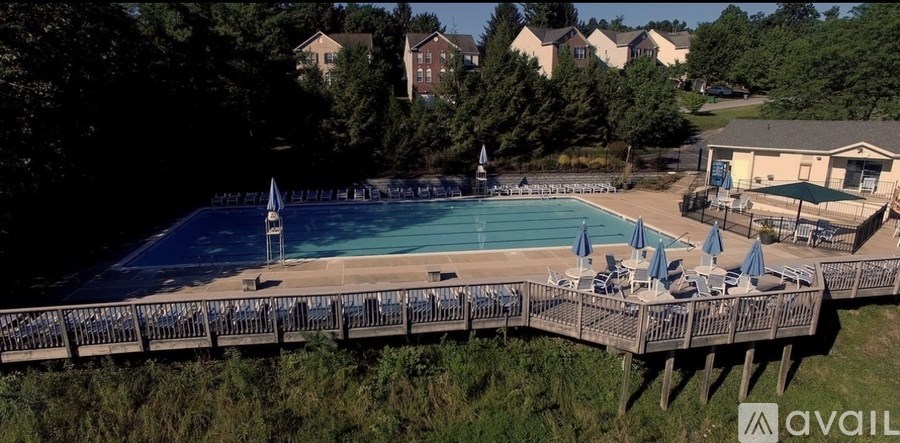 A large outdoor swimming pool with a deck and lounge chairs.