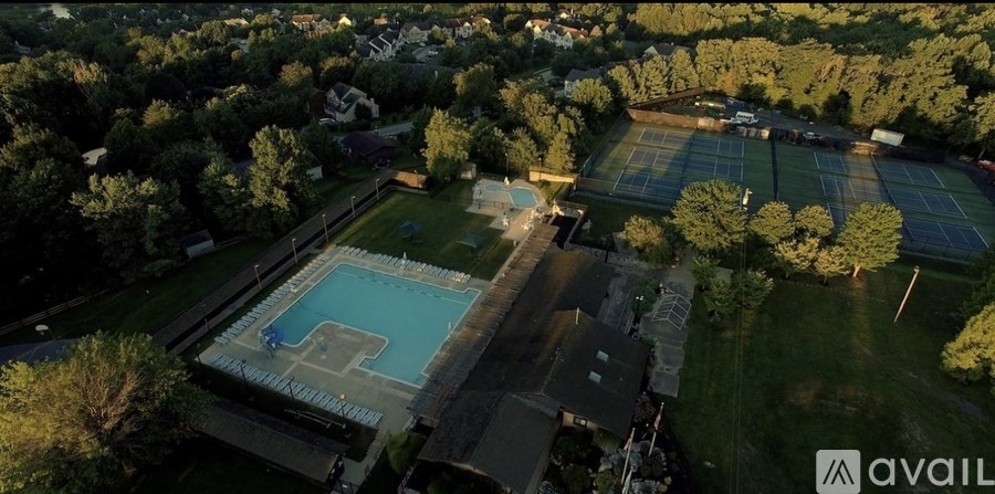 An aerial view of a tennis court surrounded by trees.