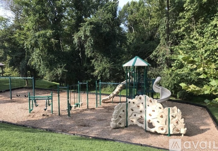 A playground with a green slide and a climbing frame.