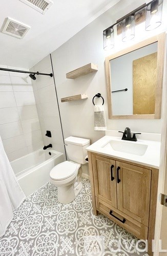 A bathroom with a toilet, sink, and a shower.