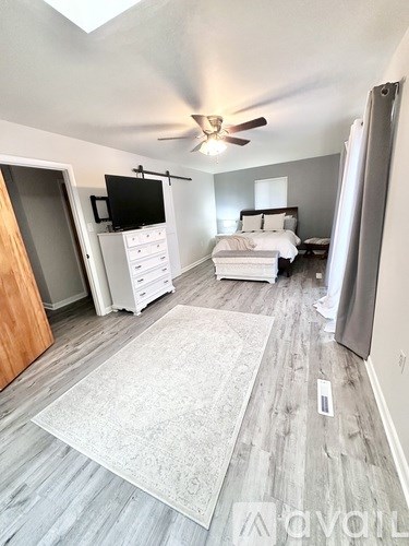 A bedroom with a bed, dresser, and tv in it.