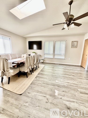 A living room with a long couch and a ceiling fan.