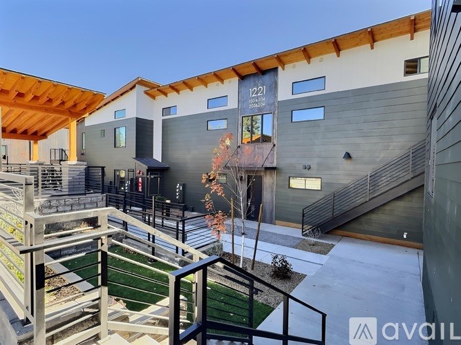 A modern building with a green lawn in front and a sign that reads "1221".