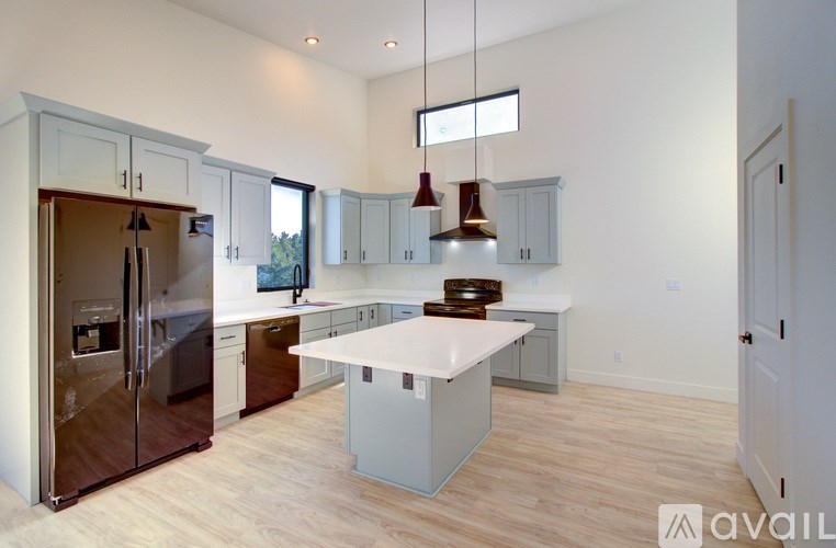 A kitchen with a white island and wooden floors.