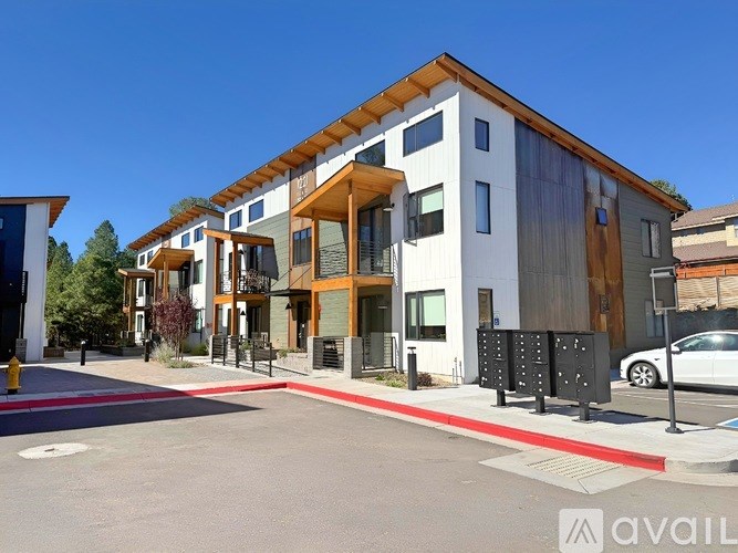 A modern building with a white facade and wooden accents.