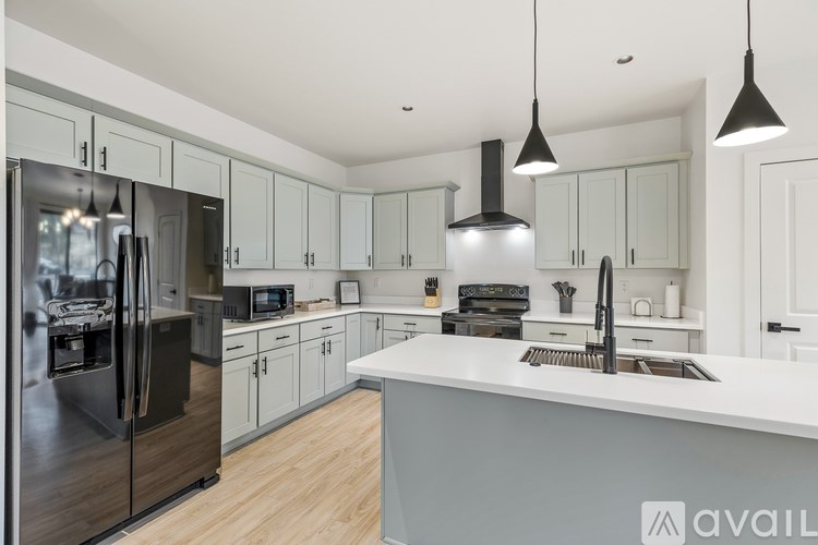 A modern kitchen with a large island and stainless steel appliances.
