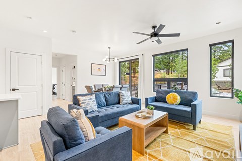 A living room with a blue couch and a yellow pillow.