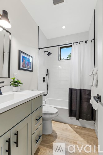 A bathroom with a white sink and a toilet.