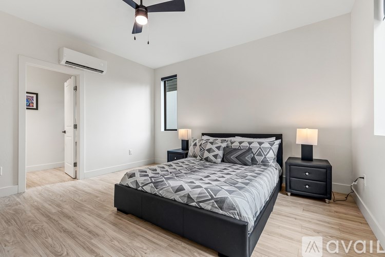 A bedroom with a bed, nightstands, and a ceiling fan.