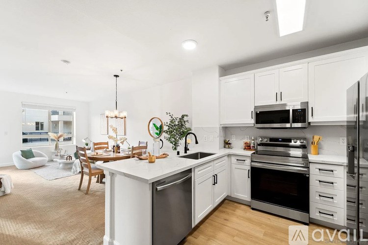 A modern kitchen with white cabinets and stainless steel appliances.