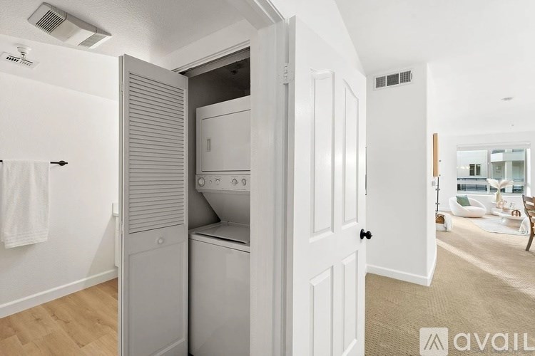 A modern laundry room with a washer and dryer built into the wall.