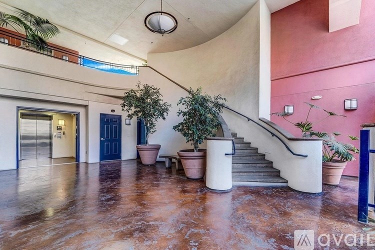 A large open space with a staircase and potted plants.