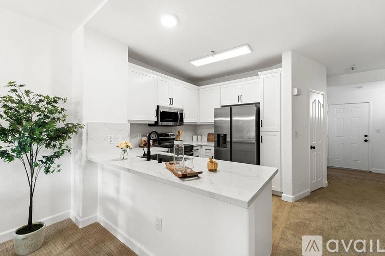 A kitchen with white cabinets and a marble countertop.