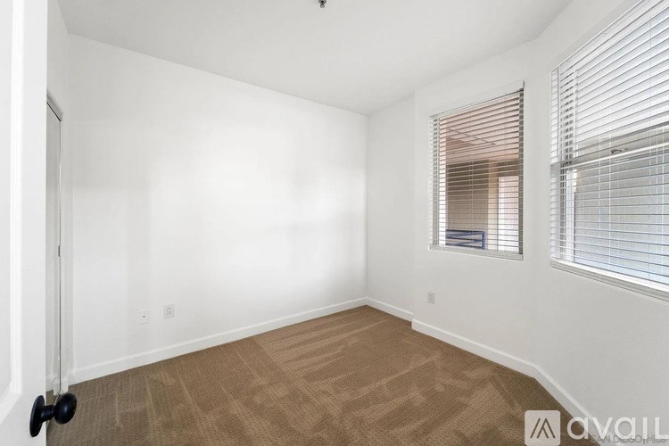 A room with a door, window, and carpeted floor.