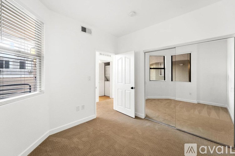 A room with a carpeted floor and a large mirror on the wall.