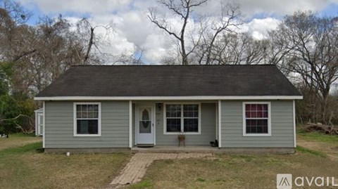 A small house with a grey roof and a porch.