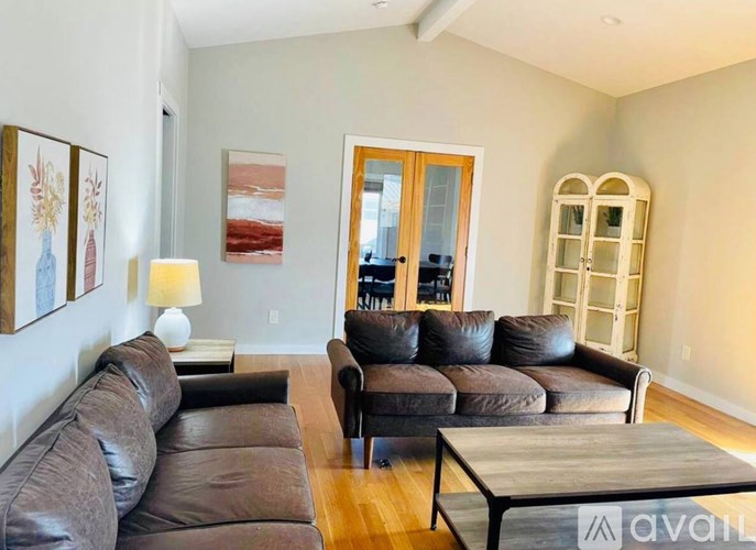 A living room with a brown leather couch and a wooden coffee table.