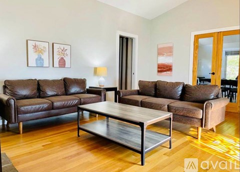 A living room with brown leather sofas and a wooden coffee table.