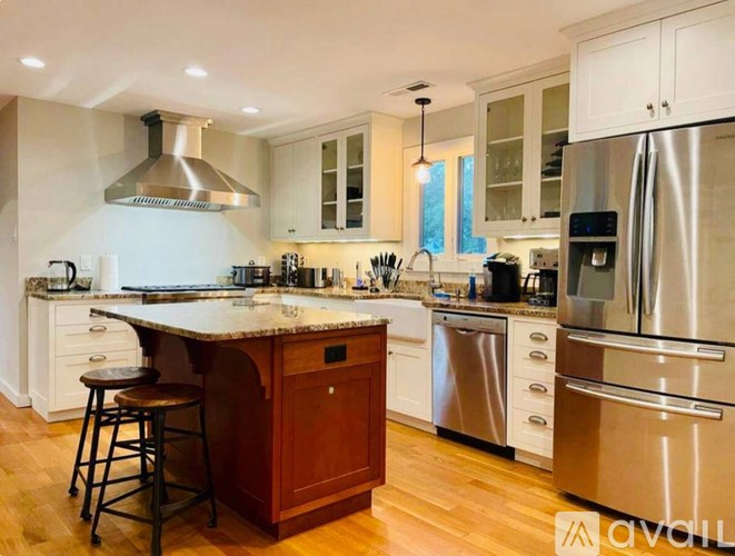 A kitchen with a wooden island and stainless steel appliances.
