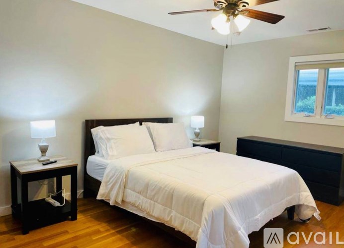 A bedroom with a bed, nightstand, and window.