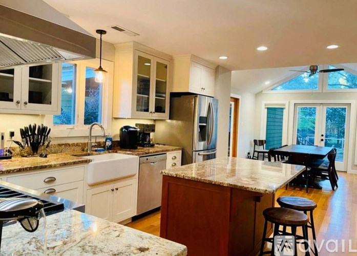 A kitchen with a marble countertop and white cabinets.