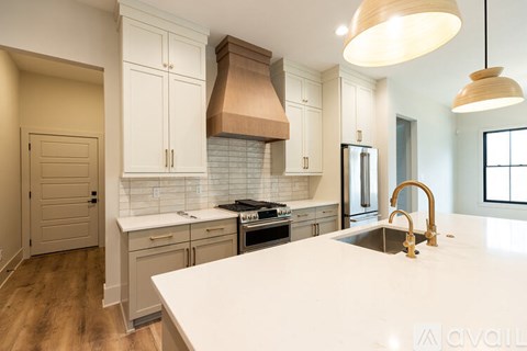 A kitchen with white countertops and wooden floors.