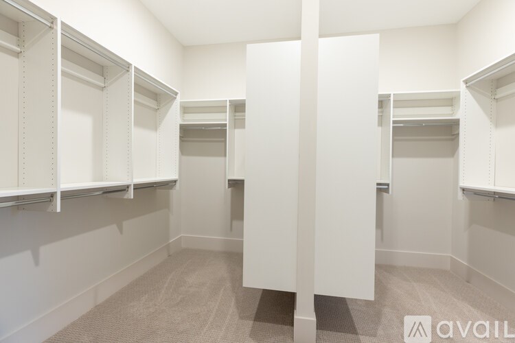 A row of white closet doors in a room.